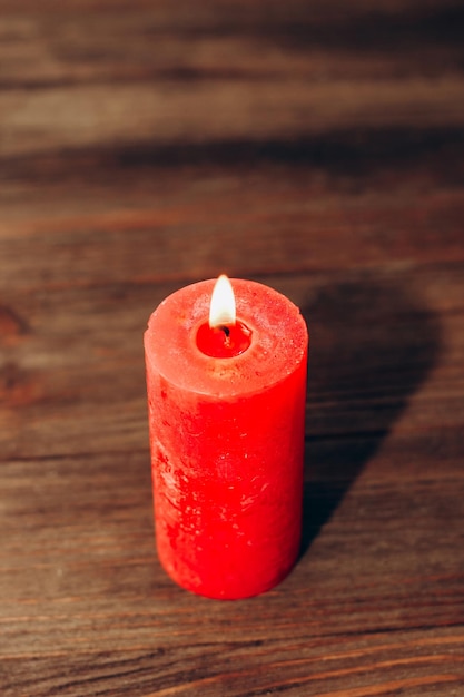 Red lit aroma candle on wooden boards background