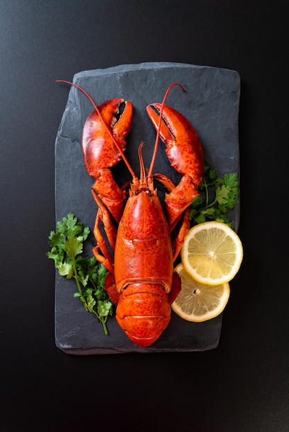 red lobster with vegetable and lemon on black slate plate