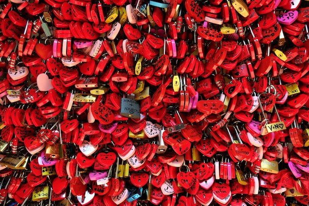 Red locks in the shape of hearts on a fence