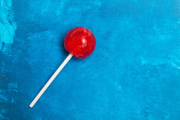 Red lollipop on a textured classic blue background