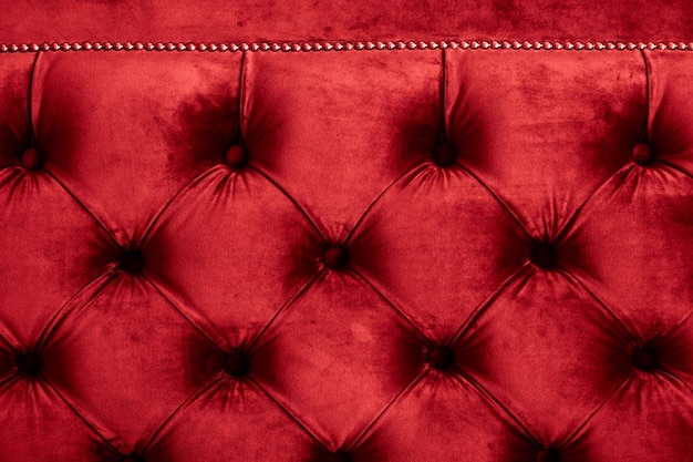 Red luxury velour quilted sofa upholstery with buttons elegant home decor texture and background