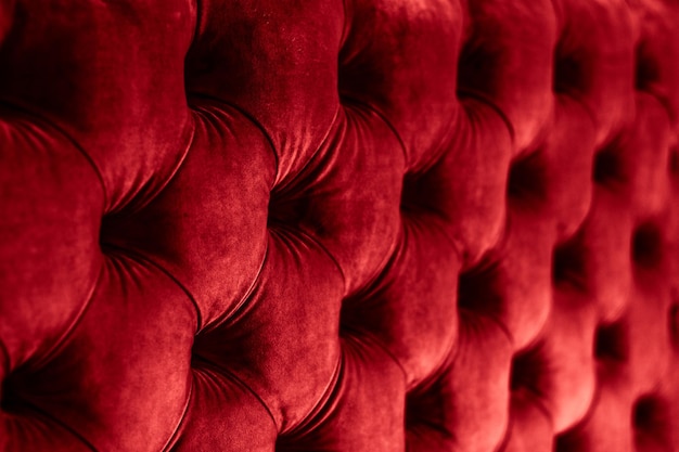Красная роскошная велюровая стеганая обивка дивана с пуговицами, элегантная текстура домашнего декора и фон