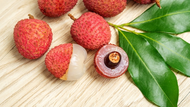 Red lychee fruit on a wooden table.