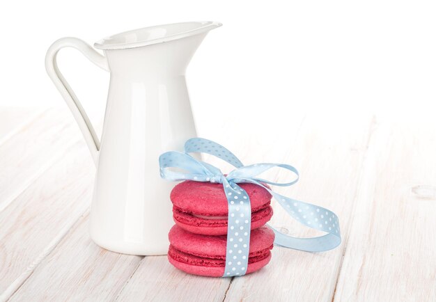 Red macarons with blue ribbon and milk jug