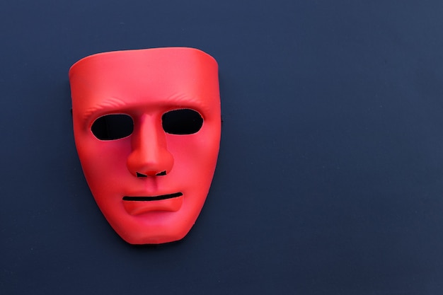 Red mask on the dark table.