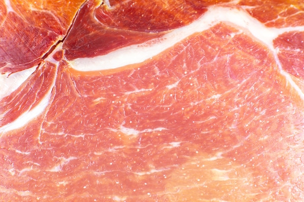 Red meat texture close up photo. Italian prosciutto crudo or jamon. Raw ham. Pork meat background.