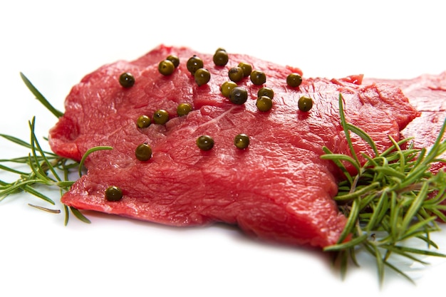 a red meat with sage and rosemary isolated on white background