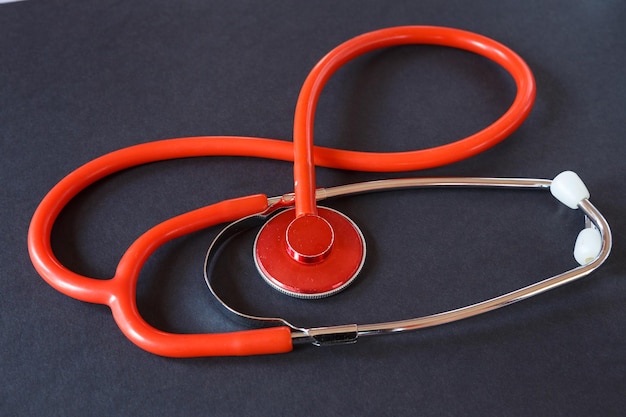 Red medical stethoscope on black background Medical instrument for listening