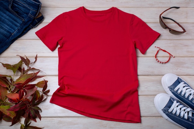 Red mens cotton Tshirt mockup with wild grass bracelet jeans sunglasses and sneakers Design t shirt template tee print presentation mock up