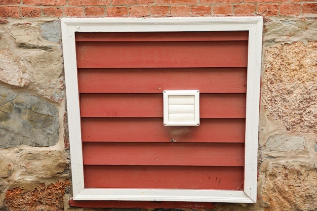 A red metal door with a white frame that says " air vent ".