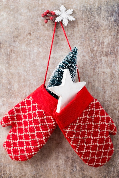 Red mittens gloves on christmas wooden table.