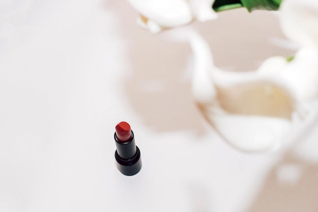 Red modern moisturizing lipstick in a black base on a light\
background