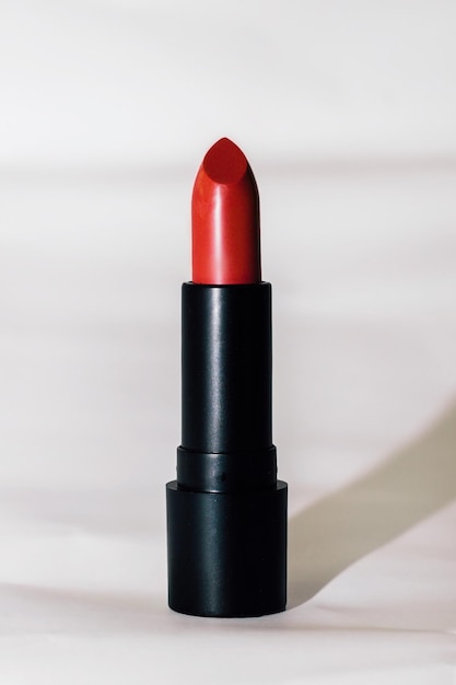 Red modern moisturizing lipstick in a black base on a light background