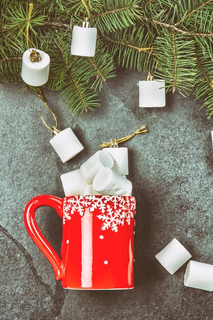 Red mug and Christmas tree branch with marshmallow. 