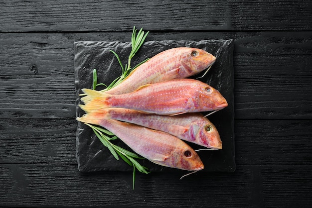 Red mullet fish Sea fish Seafood on black background Top view Free copy space