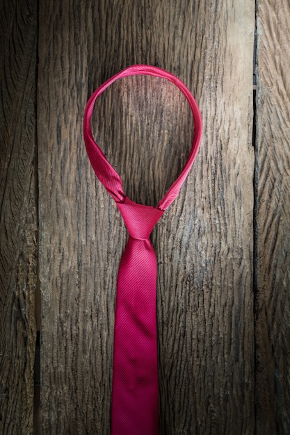 Red necktie on wooden table