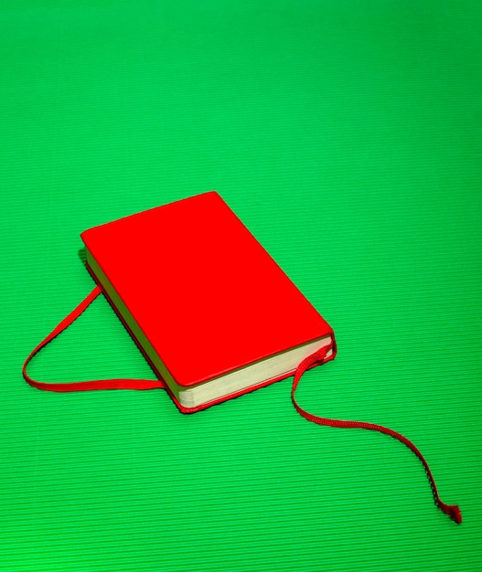 Red notebook with a bookmark on a green background