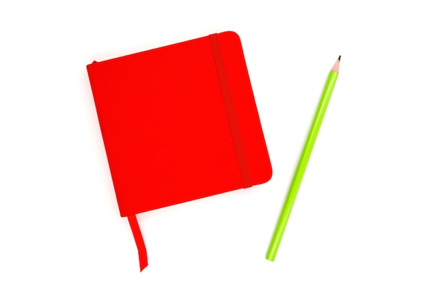 Red notebook with a green pencil