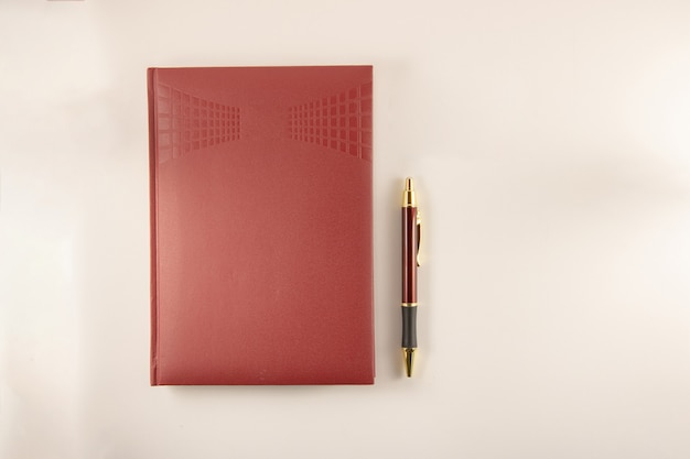 Photo red notebook with pen on white background