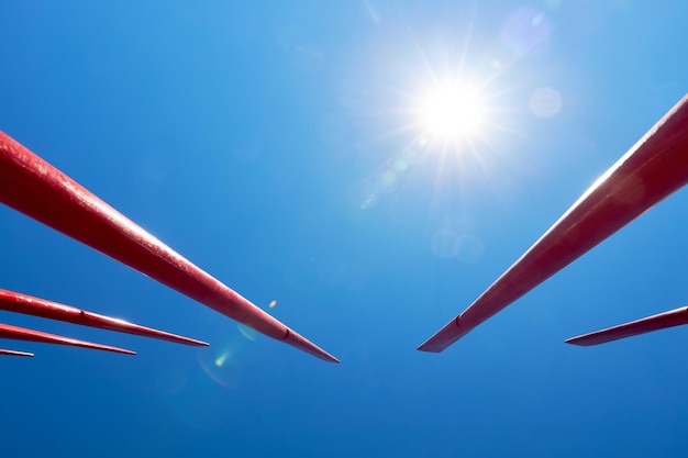 Red oars raised up against the blue sky as background