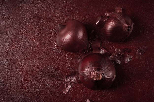 Red onion fresh raw on a dark background top view