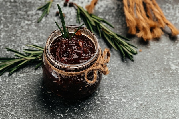 Red onion marmalade jam confiture in jar Vegetable jam on dark background Delicious sauce French cuisine Food recipe background space for text