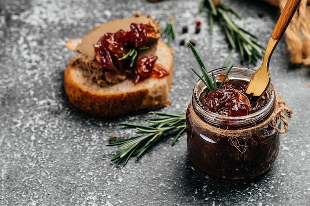 Red onion marmalade jam confiture in jar Vegetable jam on dark background Delicious sauce French cuisine Food recipe background space for text