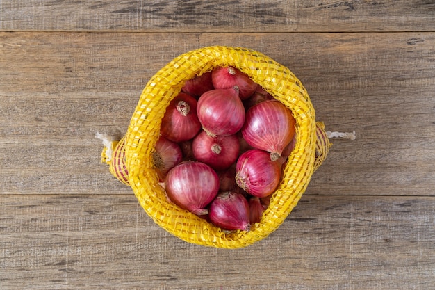 Photo red onion on shabby wooden board.