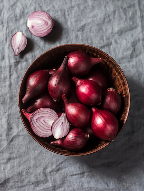 Red onions in a ceramic bowl on a gray background top view Spanish onion
