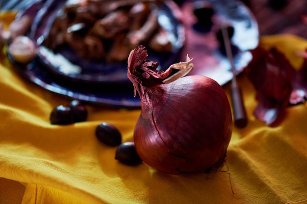 Red onions on the napkin is yellowNext to olives