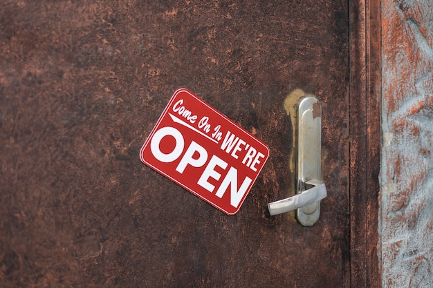 Photo red open sign on rusty door