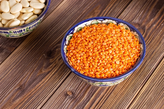 Red or orange lentil in a bowl on wooden