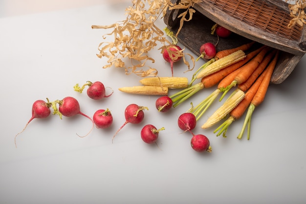 The red and orange radishes are on the white cloth