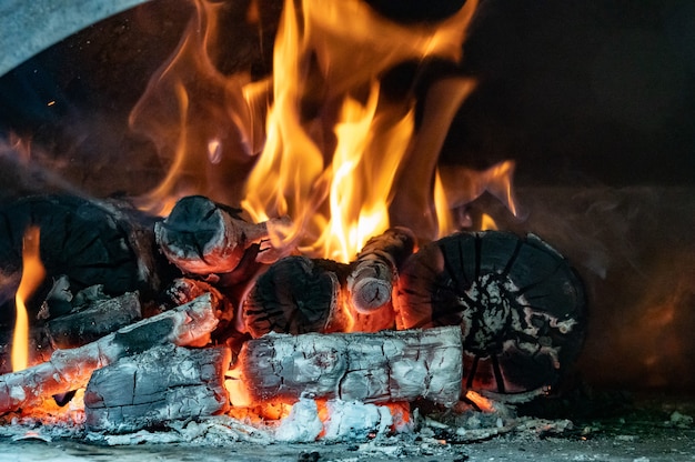 Fiamme rosse, arancioni e gialle da legna da ardere in un forno