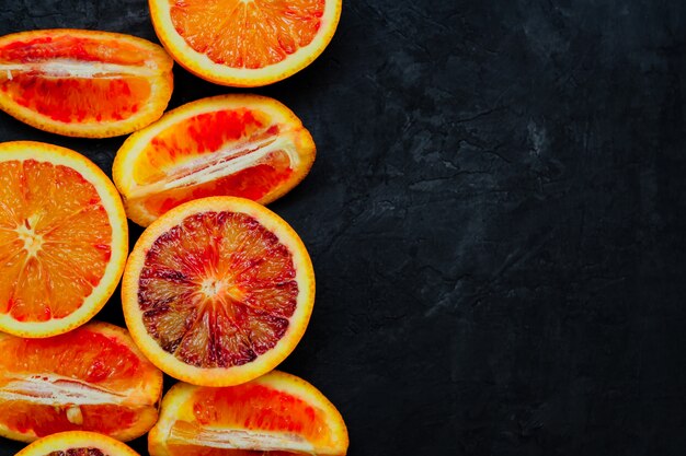 Red oranges, delicious orange fruits, cut into halves and quarters for desserts preparation. Top view, copy space.