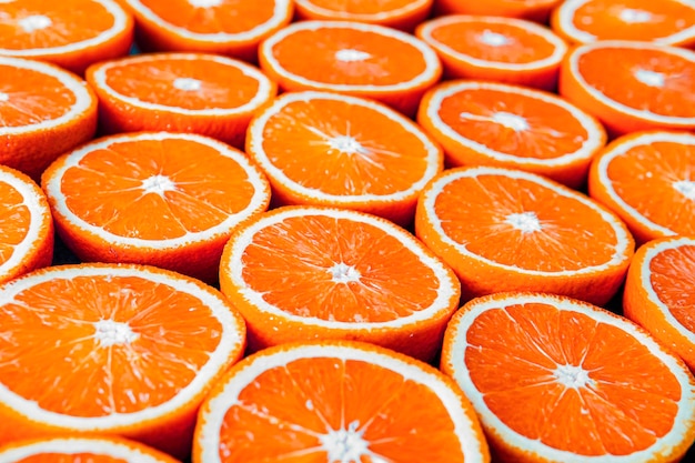 Red oranges or grapefruits are cut in half on a black background.