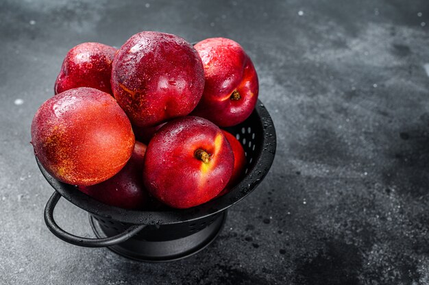 Red organic nectarines in a colander 