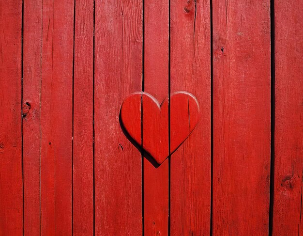 red painted wooden wall with heart as a symbol of love and friendship