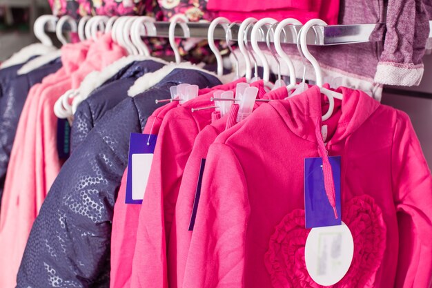 Photo red pants that stacked in rows on the white shelf in a clothing store