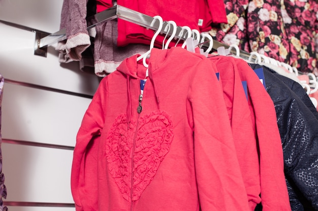 Red pants that stacked in rows on the white shelf in a clothing store