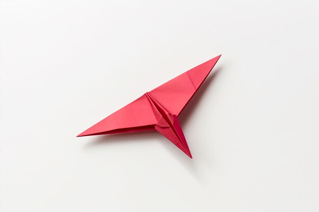 A red paper airplane is on a white background