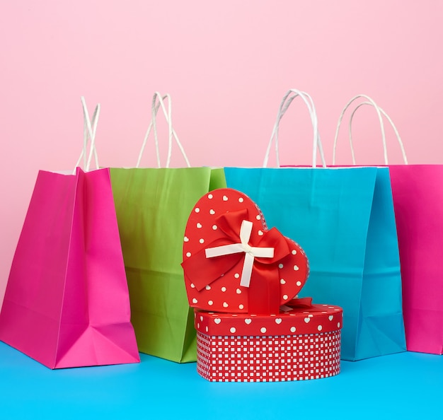 Red paper box with a gift and paper bags for shopping