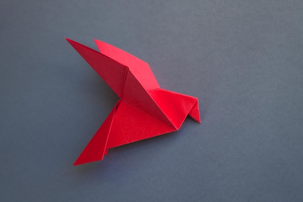 Red paper dove origami isolated on a grey background