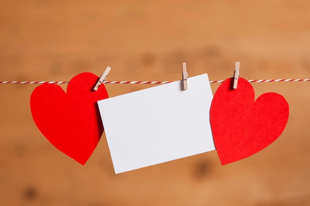 Red paper heart and blank white label pegged to a string