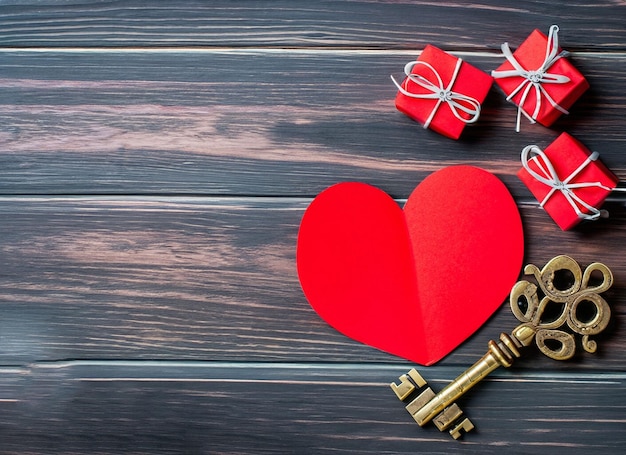 Красное бумажное сердце и старый ключ на темном деревянном фоне. День Святого Валентина 39. Копирование пространства