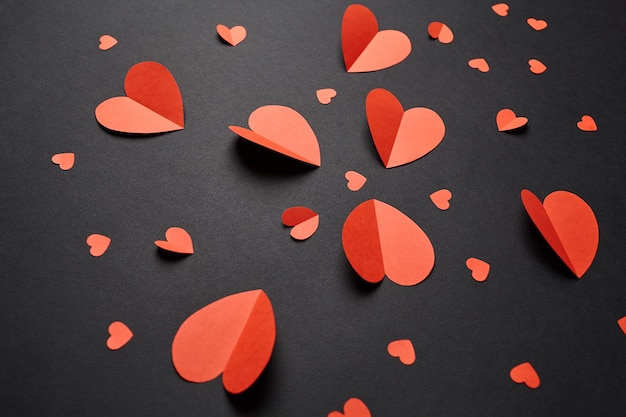 Red paper hearts on black background