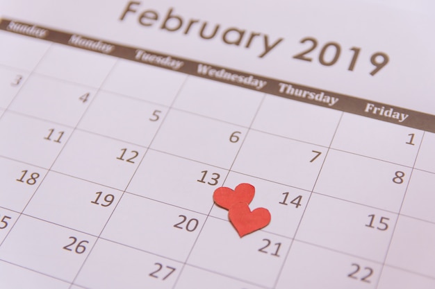 Red paper hearts on calendar page