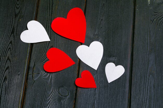 Красные бумажные сердечки любят класть на старую деревянную поверхность