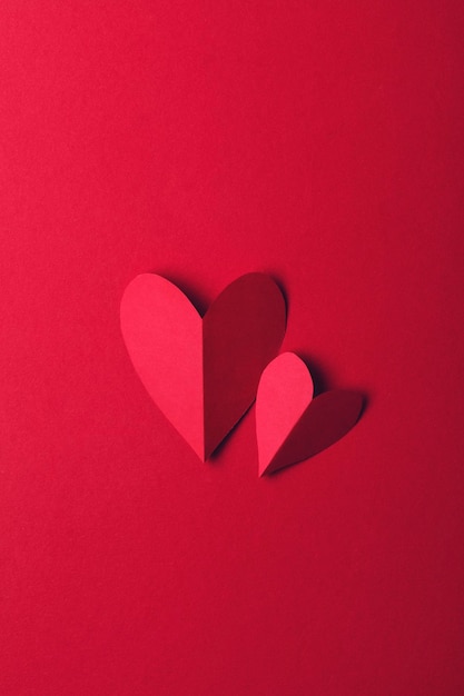 Red paper love heart on a plain red background Valentines day romance background