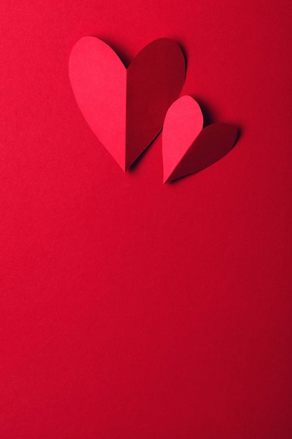 Red paper love heart on a plain red background Valentines day romance background